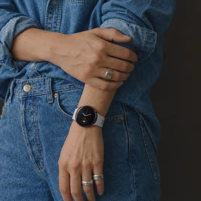 A Veyra with a white strap on the wrist of a denim shirt